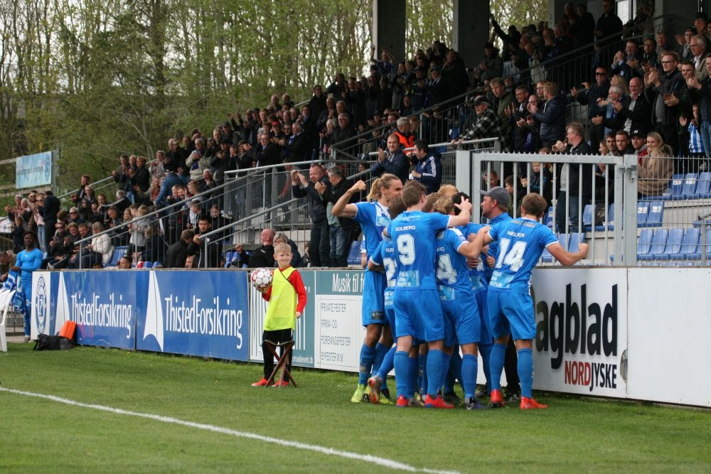 fodboldspillere fejrer mål på stadion