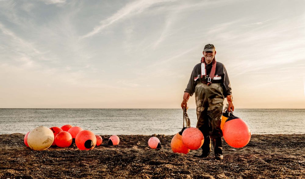 Fisker på arbejde på stranden