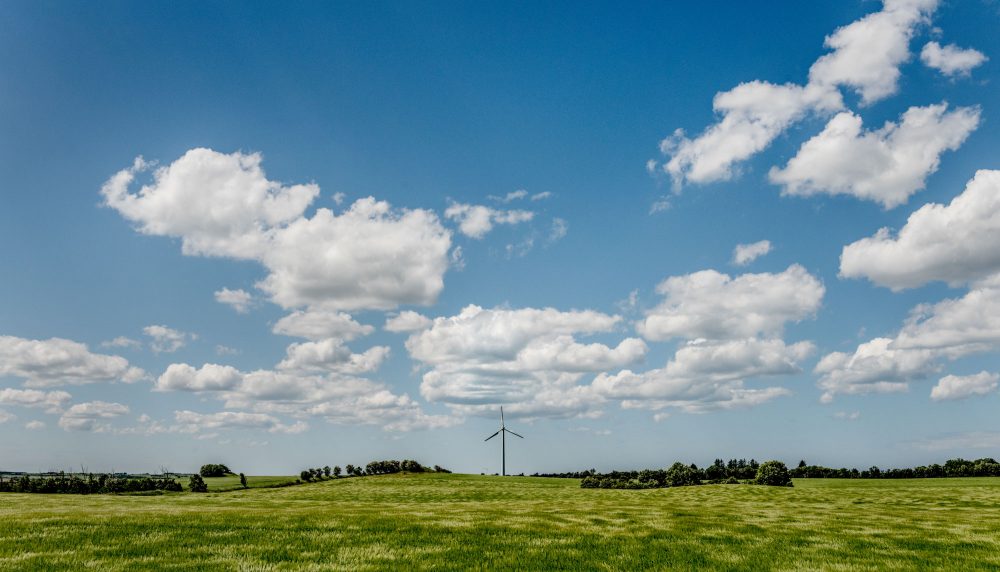 Vindmølle på mark under blå himmel