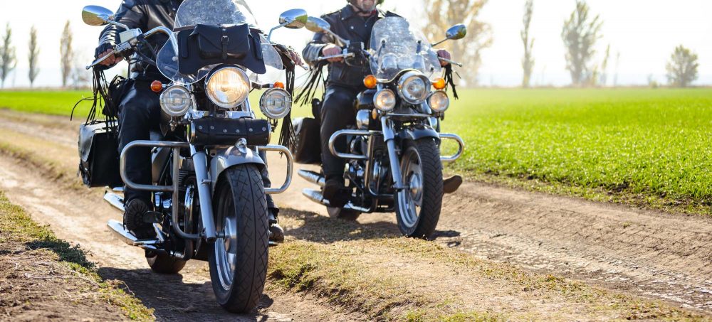 to mænd der kører motorcykel på markvej
