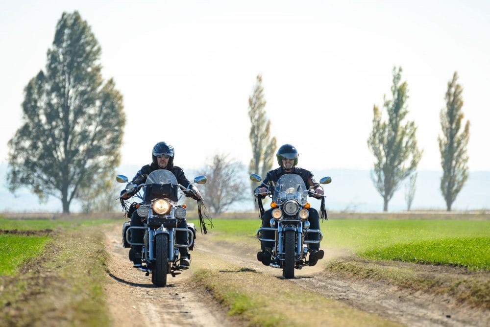 to mænd der kører motorcykel på markvej