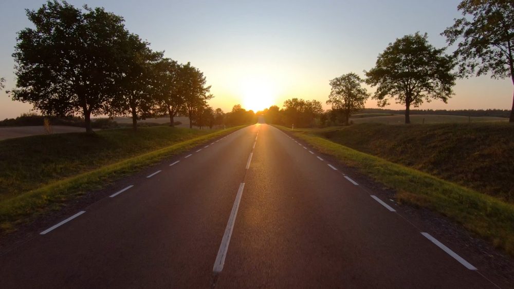 en solnedgang over landevej