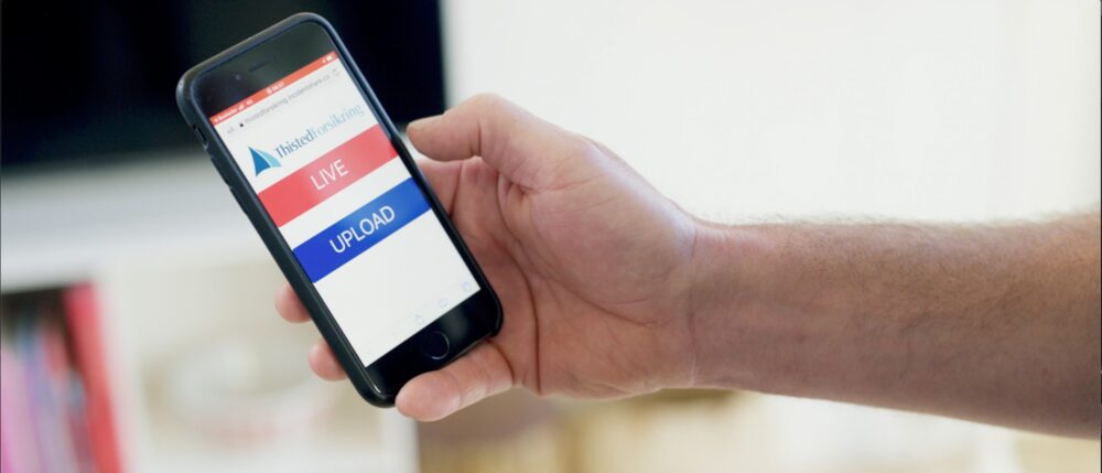 Hånd holder mobil med sms-løsning