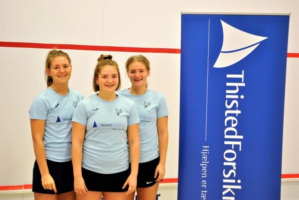 tre piger der står ved et banner