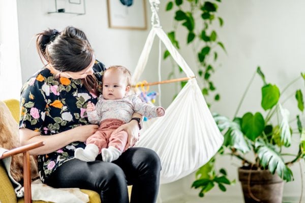 en kvinde sidder i stol med en baby