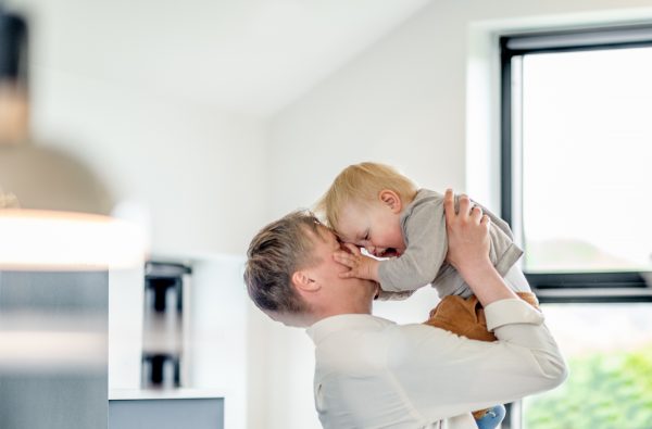 en mand leger med baby i et hus