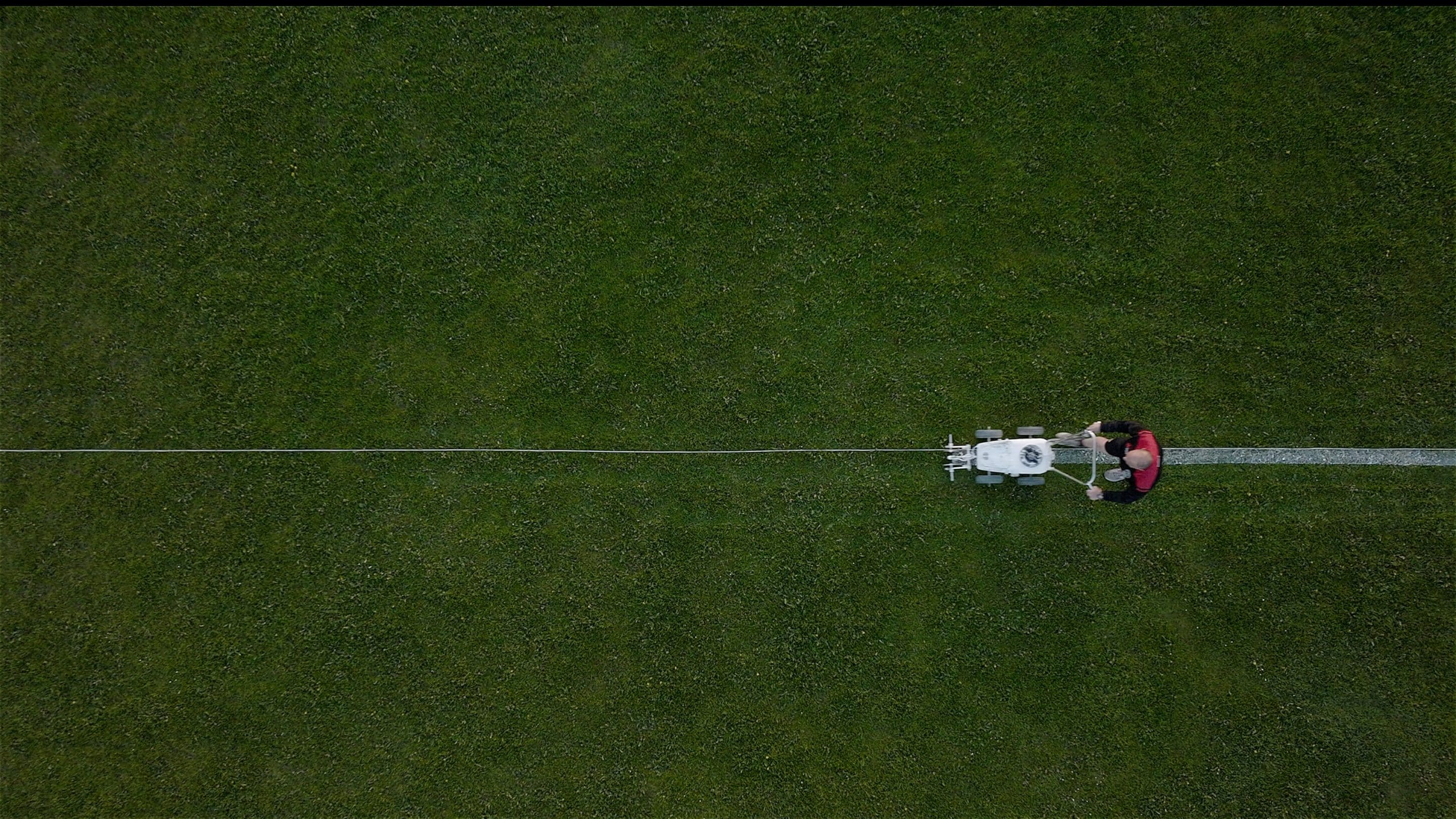 En mand der tegner streger på en fodboldbane