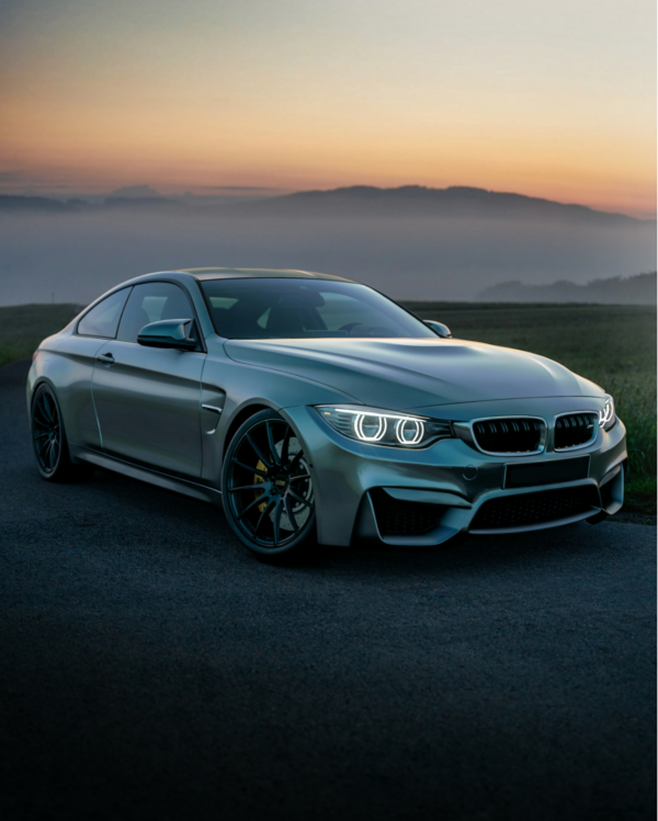 En BMW holder på en landevej med en solnedgang i baggrunden
